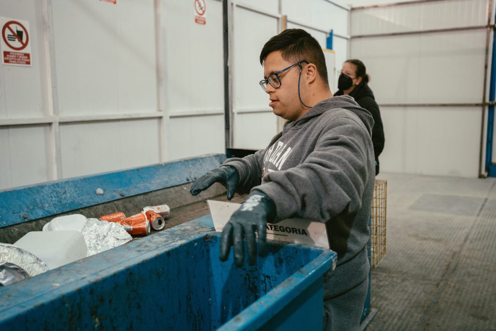 Trabajador clasificando envases en la cinta de la planta
