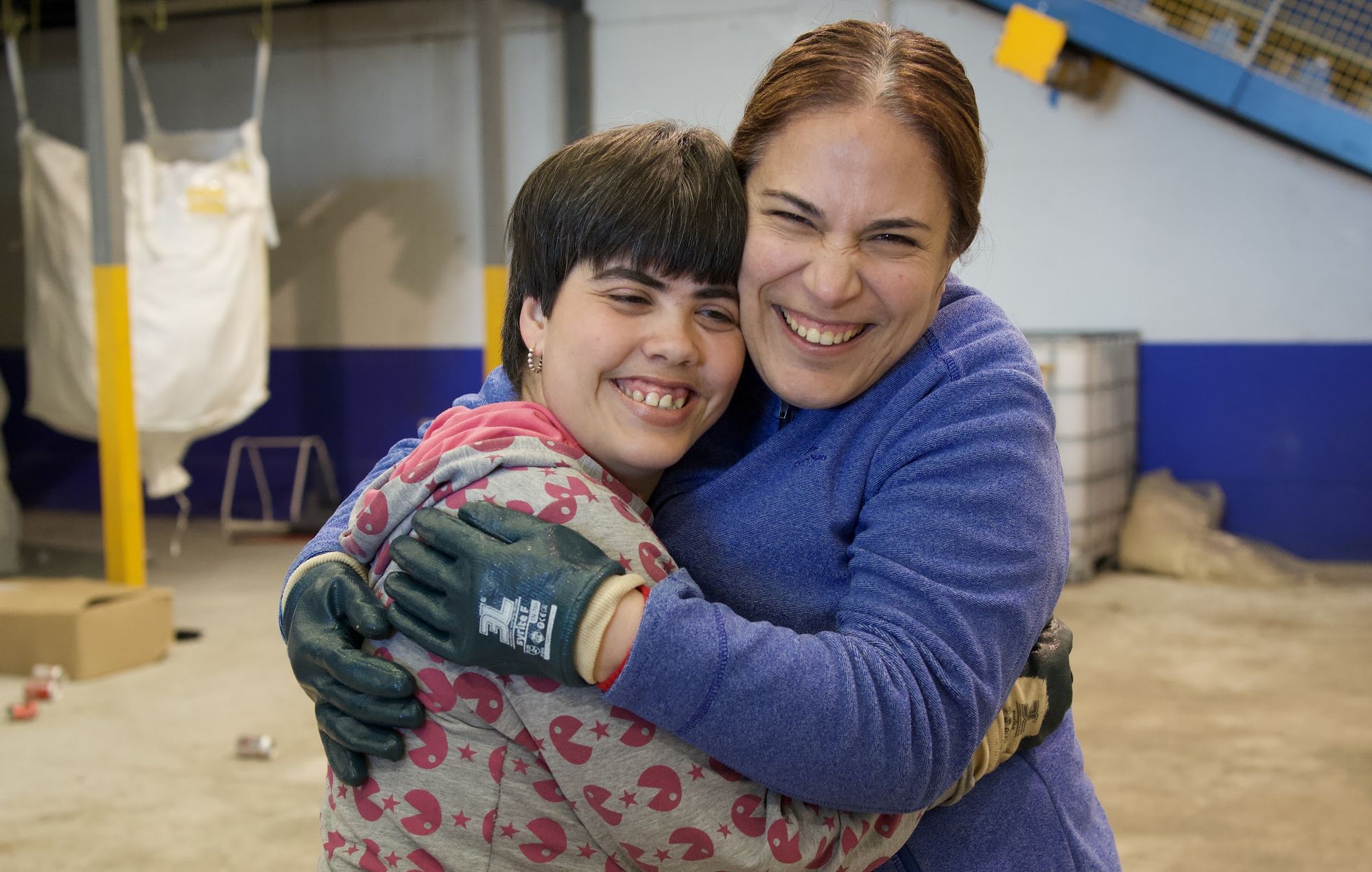 Dos compañeras de la Fundación se abrazan en la planta