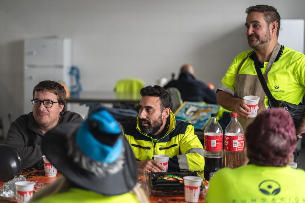 Compañeros de la Fundación riendo alrededor de una mesa en la planta