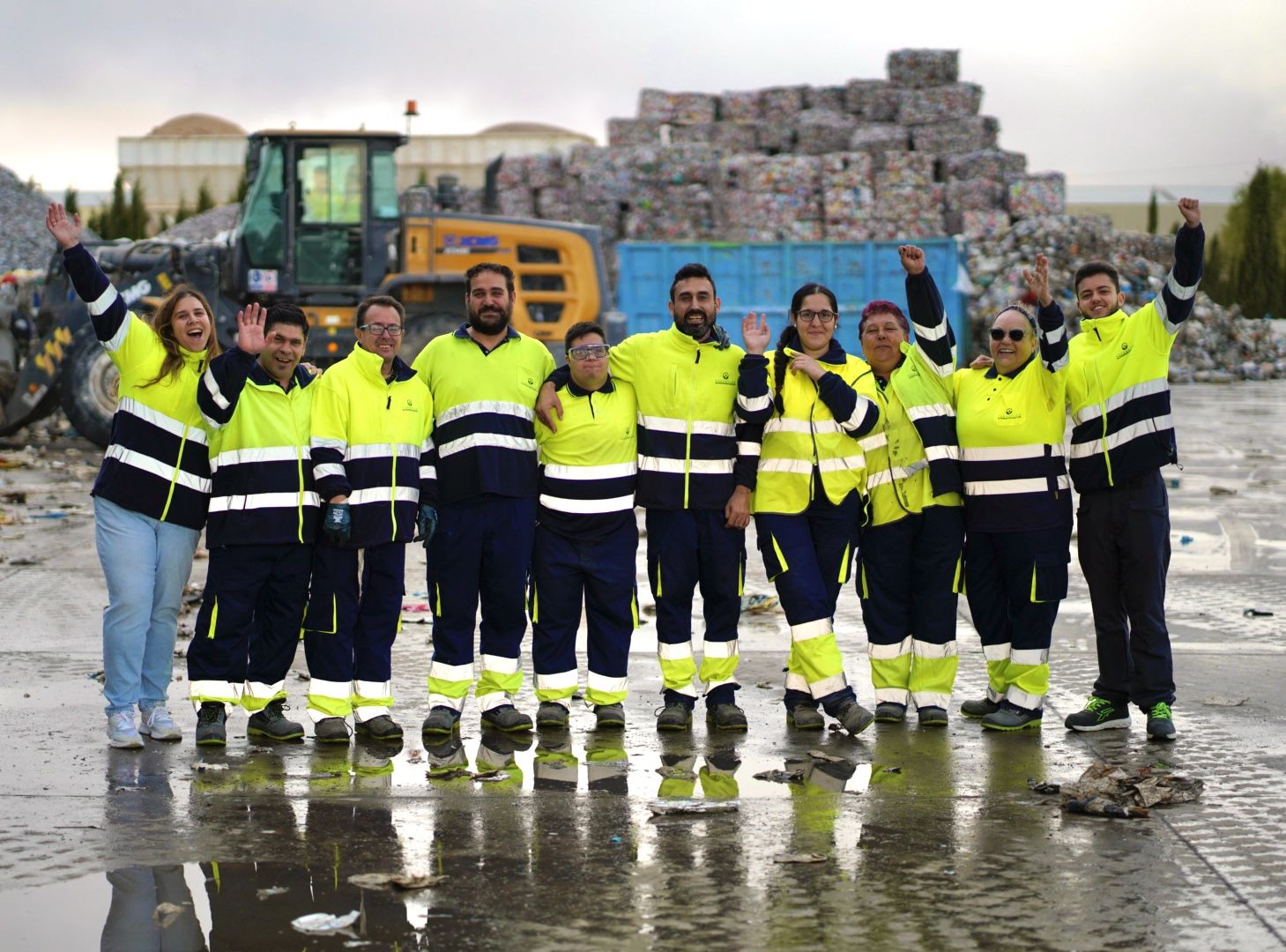 Equipo de la Fundación Almanara Natur con ropa de trabajo reflectante frente a las balas de envases