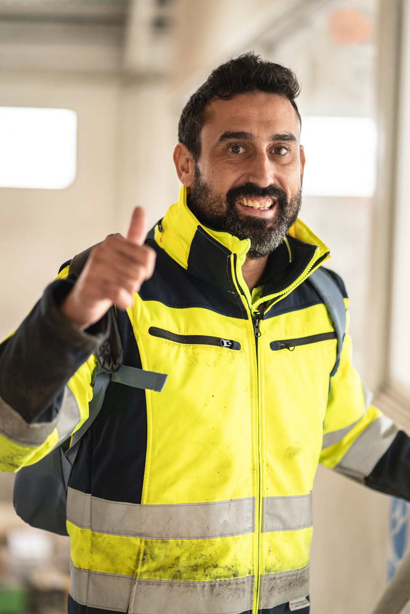 Trabajador de la Fundación con chaqueta reflectante levantando el pulgar